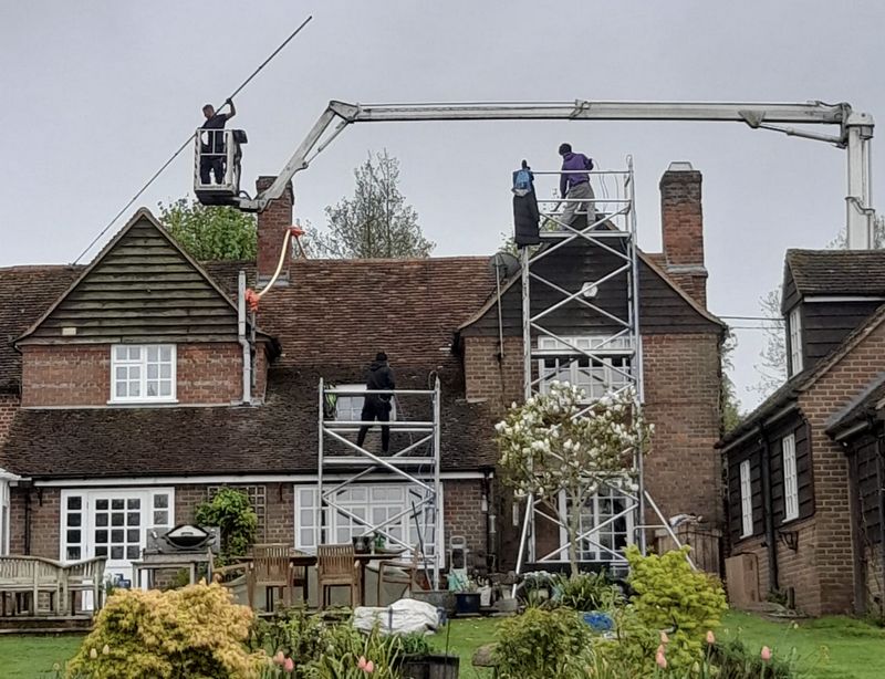 The Moss Cleaners using cherry picker and scaffolding to clean roof safely and professionally in Netley, Hampshire